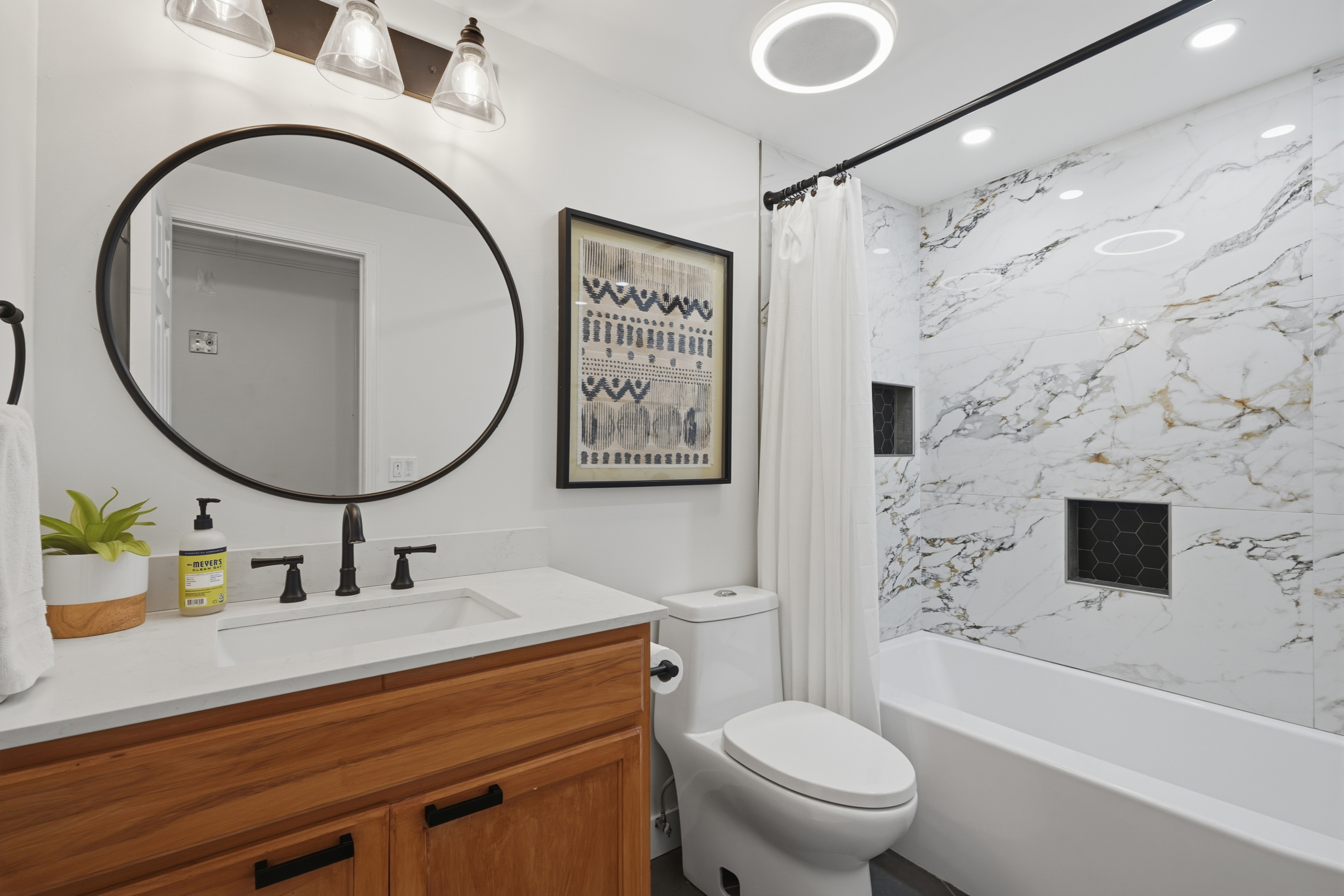 Bathroom with marble-look tile and wood vanity